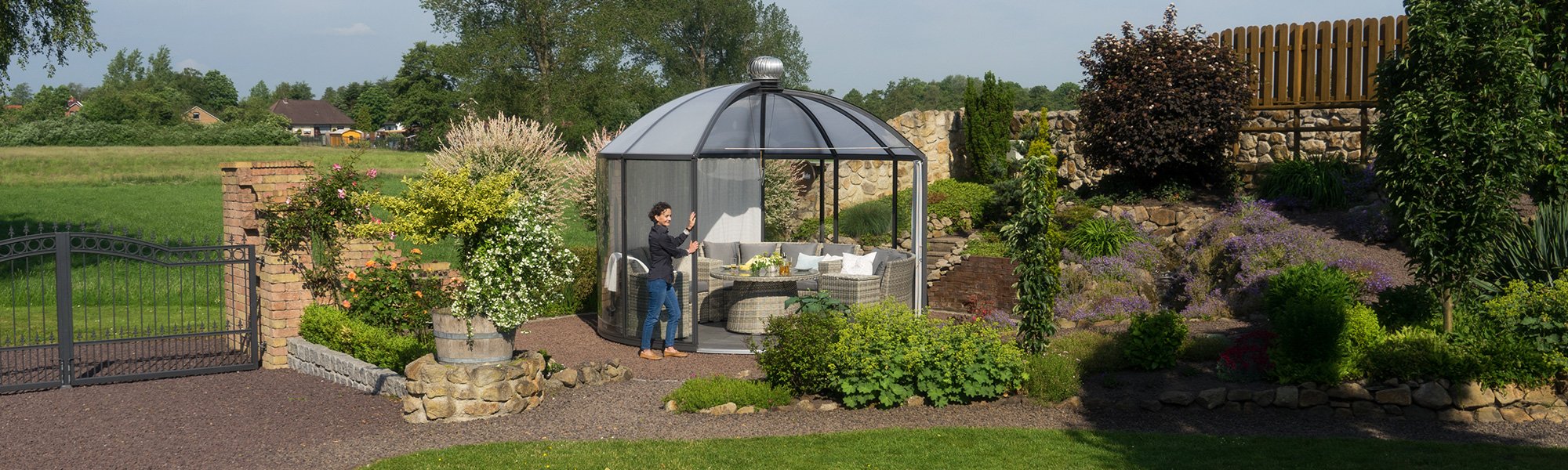 Pavillion in einem Garten wird von einer Person geöffnet